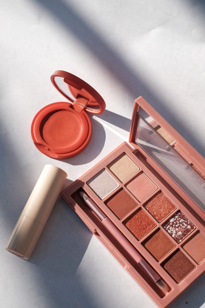 Top View of Eyeshadow, Blush and Lipstick on White Background